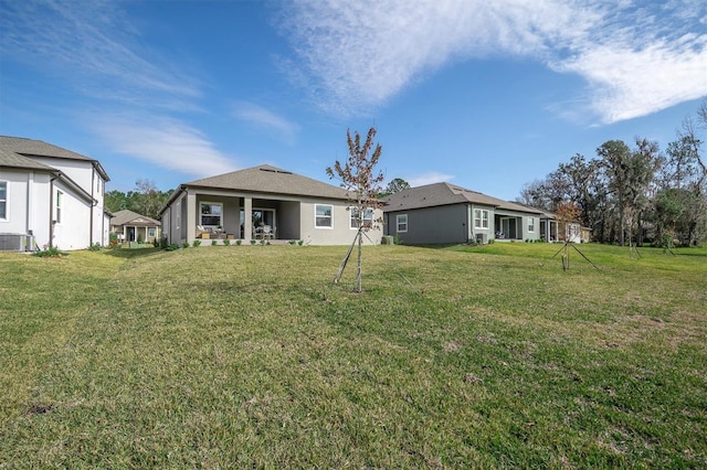 rear view of house with a yard and central AC unit