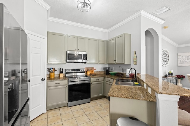 kitchen with kitchen peninsula, appliances with stainless steel finishes, a textured ceiling, and sink