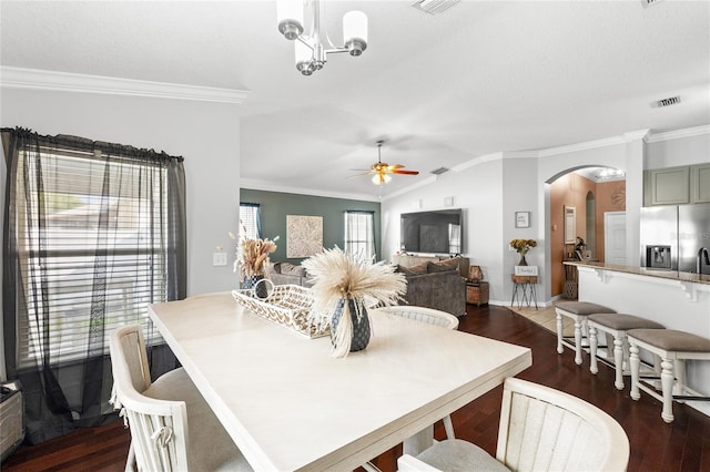 dining space featuring ceiling fan with notable chandelier, vaulted ceiling, and ornamental molding