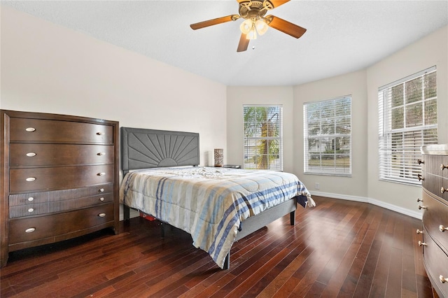 bedroom with multiple windows, ceiling fan, and dark wood-type flooring