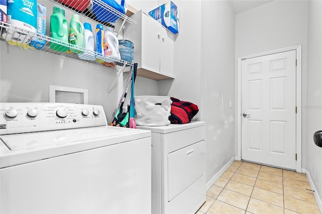 laundry area with independent washer and dryer and light tile patterned floors