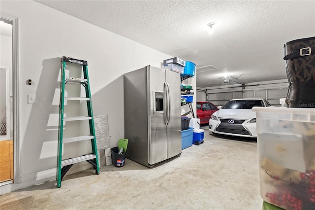 garage with stainless steel fridge with ice dispenser and a garage door opener