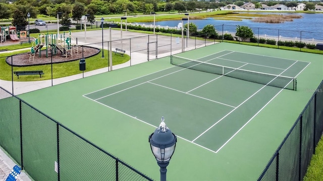 view of tennis court with a water view, a playground, and basketball court