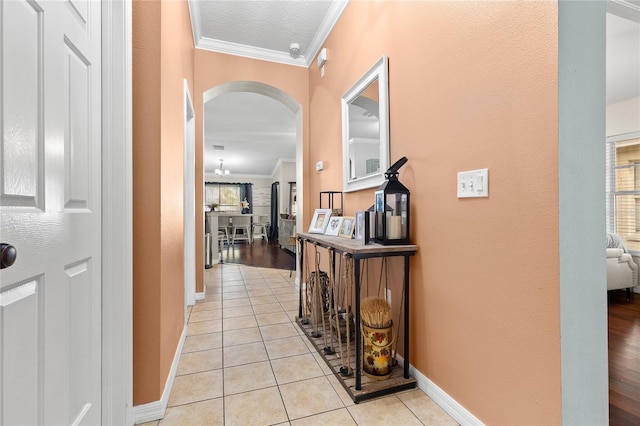 hallway with crown molding and light tile patterned floors