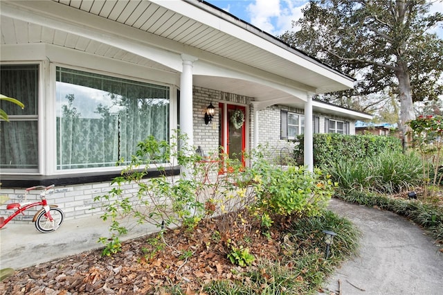 view of exterior entry featuring covered porch