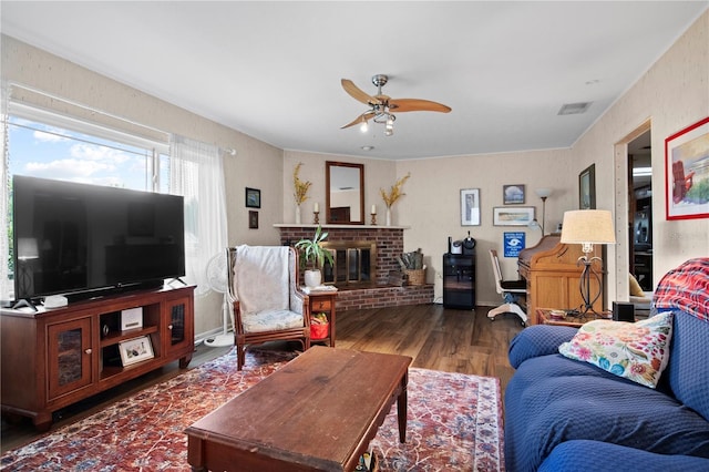 living room featuring ceiling fan, a fireplace, and dark hardwood / wood-style floors