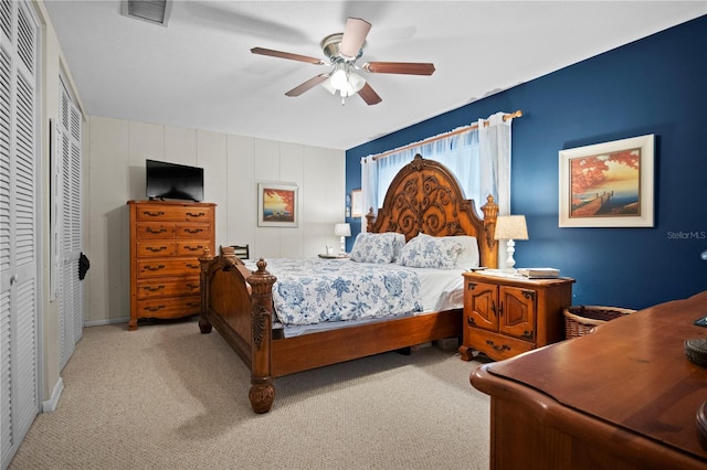 bedroom featuring ceiling fan, light colored carpet, and a closet