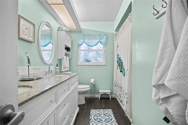 bathroom featuring tile patterned flooring, vanity, a textured ceiling, and toilet