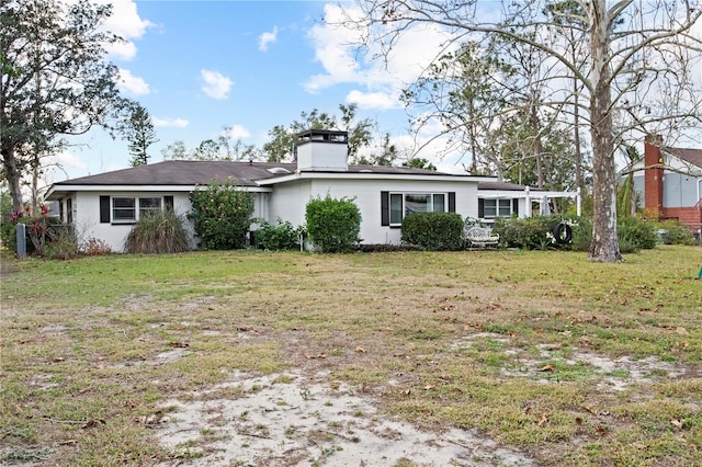 back of house with a lawn