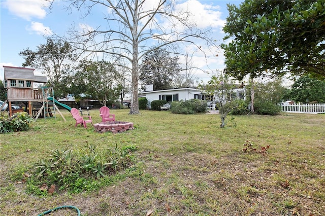 view of yard featuring a playground and an outdoor fire pit