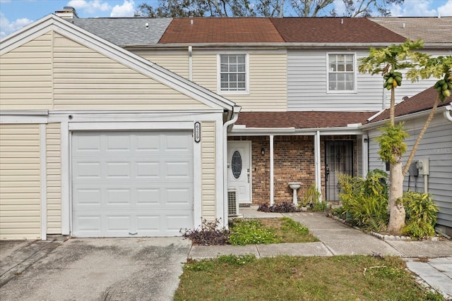 view of front of house with central air condition unit and a garage