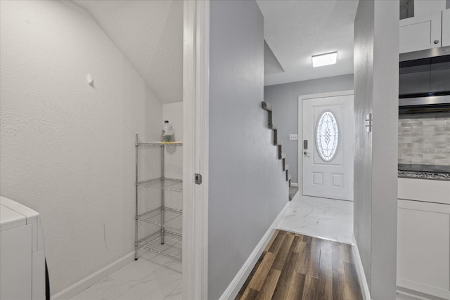 foyer entrance featuring washer / dryer and a textured ceiling