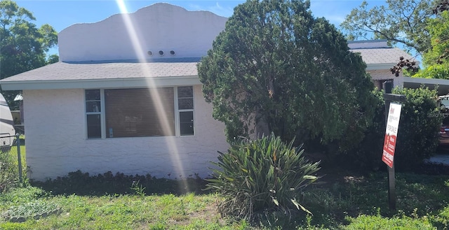 509 Rosery Rd NW, Largo, FL 33770 - view of side of home featuring a shingled roof and stucco siding