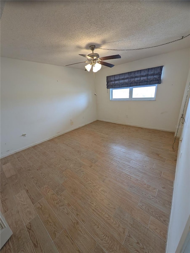 empty room with ceiling fan, a textured ceiling, and light hardwood / wood-style flooring