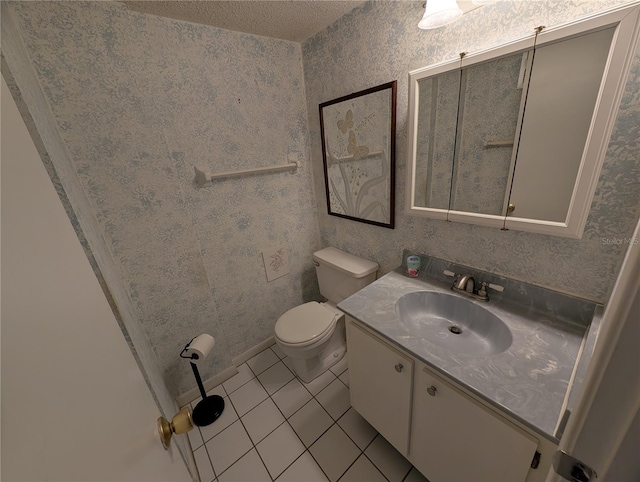 bathroom with toilet, vanity, and tile patterned flooring