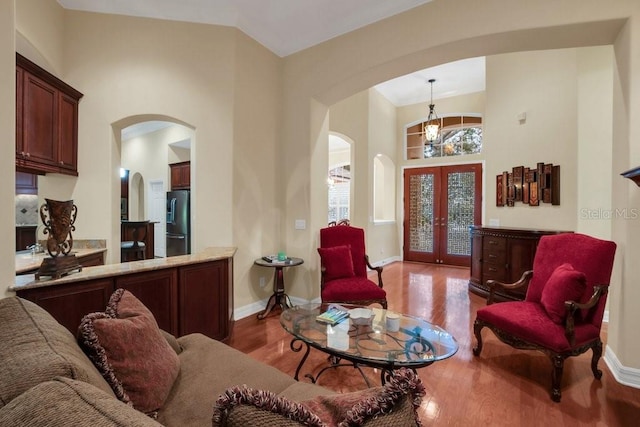 living room featuring french doors, hardwood / wood-style floors, and an inviting chandelier