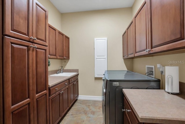 laundry area featuring cabinets, sink, and washer / dryer