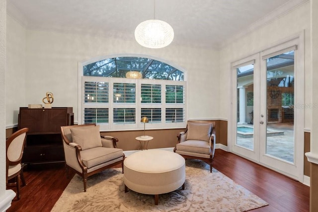 sitting room featuring hardwood / wood-style floors, a chandelier, french doors, and ornamental molding