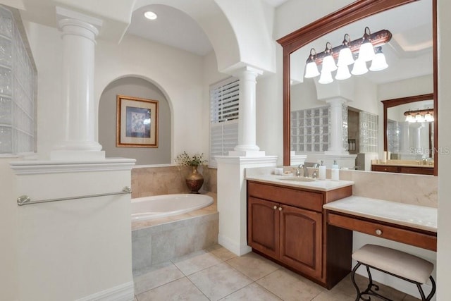 bathroom featuring tile patterned flooring, vanity, and tiled tub