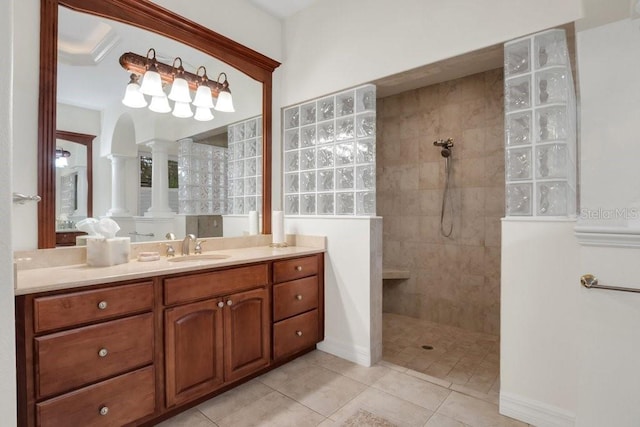 bathroom with tile patterned flooring, vanity, and tiled shower