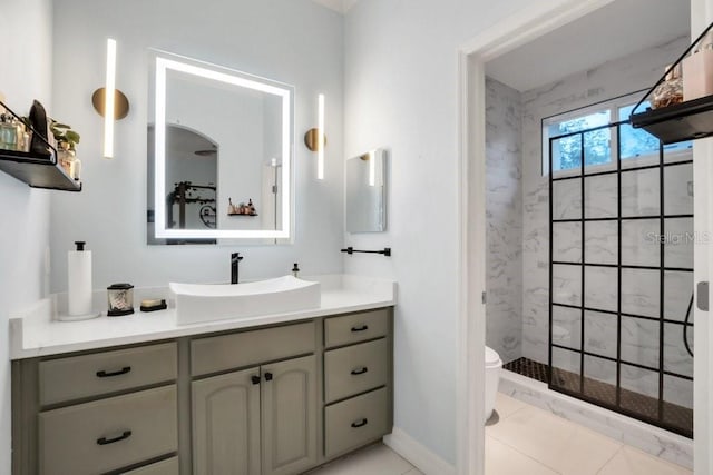 bathroom featuring tiled shower, tile patterned floors, vanity, and toilet