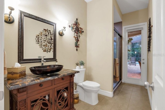 bathroom with tile patterned flooring, vanity, toilet, and an enclosed shower