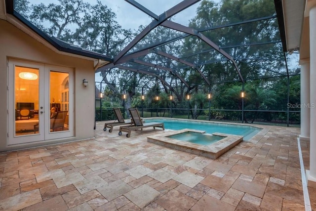 view of swimming pool featuring glass enclosure, an in ground hot tub, a patio, and french doors