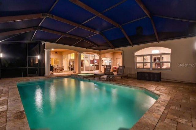 pool at twilight featuring a lanai, a patio area, and ceiling fan