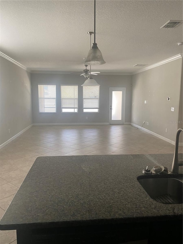 interior space featuring ornamental molding, visible vents, a sink, and light tile patterned flooring