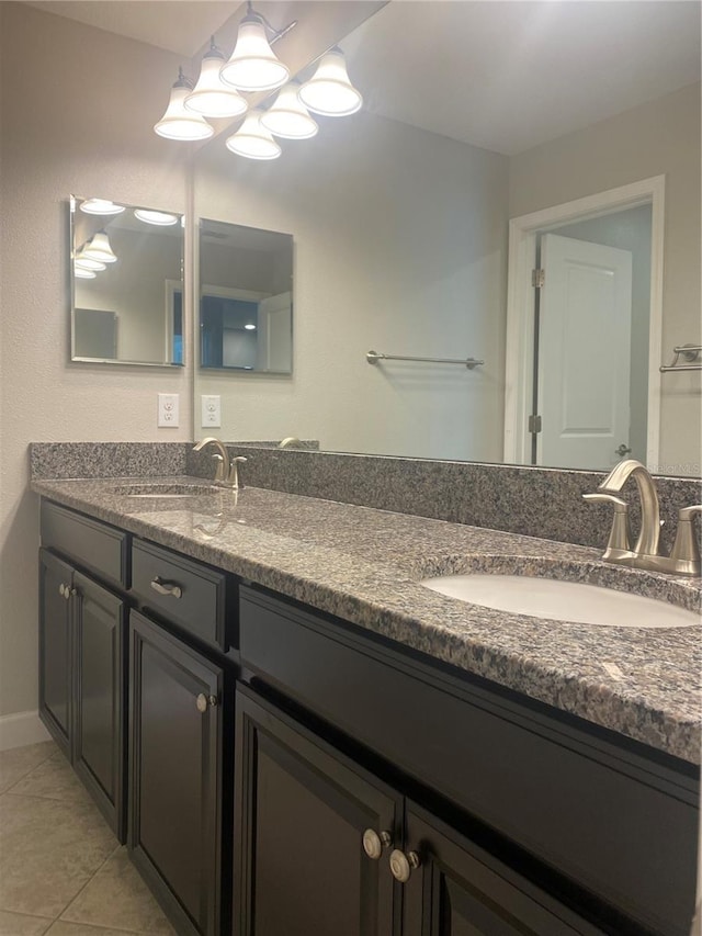 full bath featuring double vanity, tile patterned flooring, and a sink