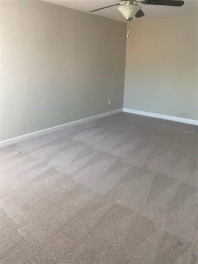 empty room featuring ceiling fan, carpet flooring, and baseboards