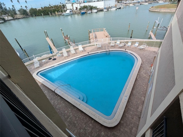 view of pool with a patio and a water view