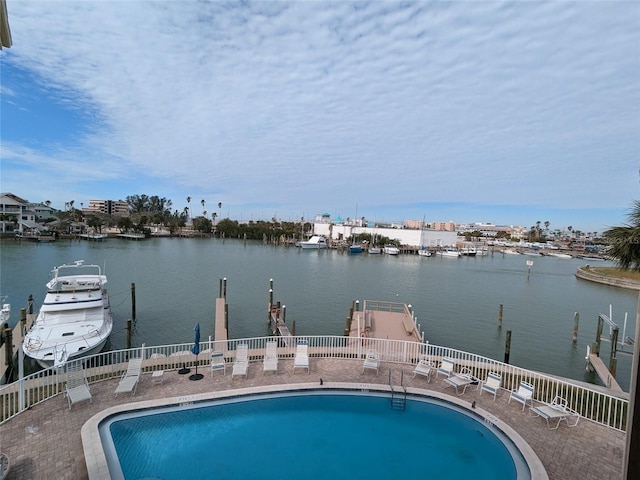 view of swimming pool with a patio area, a dock, and a water view