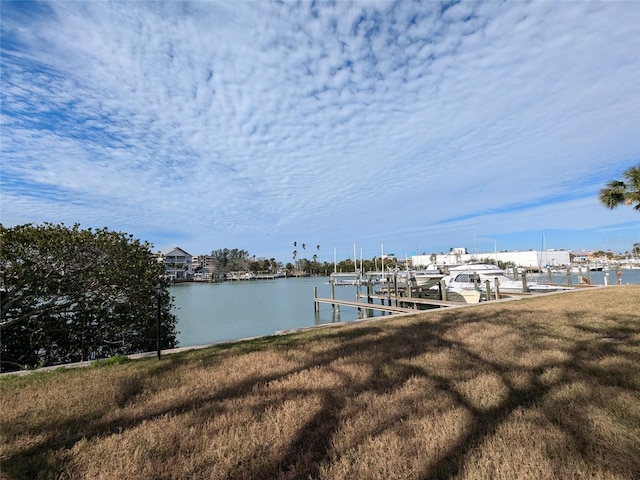 dock area with a lawn and a water view