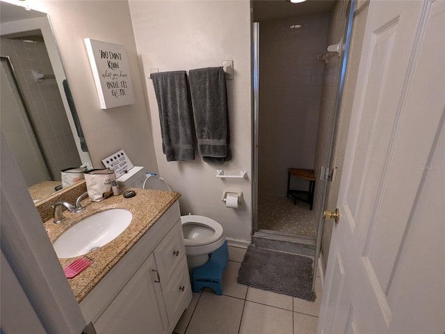 bathroom with tile patterned floors, a shower with door, vanity, and toilet