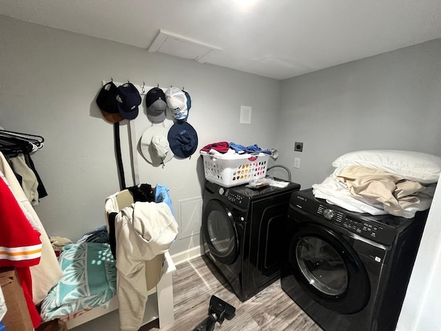 clothes washing area featuring washer and clothes dryer and light hardwood / wood-style flooring