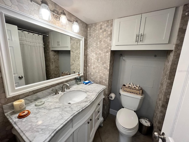 bathroom featuring tile patterned floors, vanity, toilet, and a textured ceiling