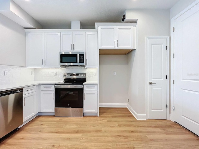 kitchen featuring white cabinets, appliances with stainless steel finishes, and light hardwood / wood-style flooring