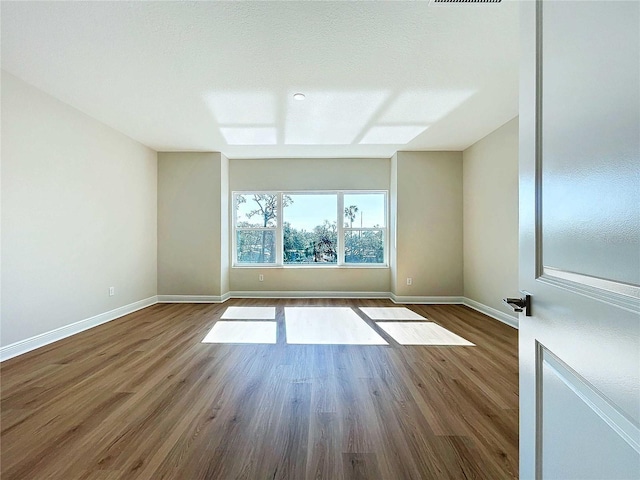 spare room with wood-type flooring and a textured ceiling