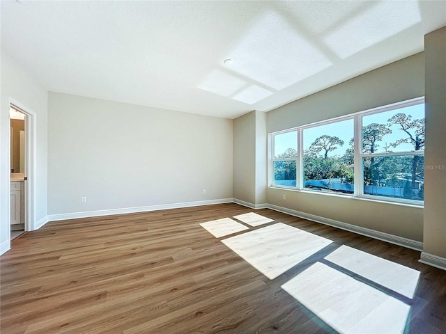 unfurnished room featuring dark hardwood / wood-style flooring and a textured ceiling