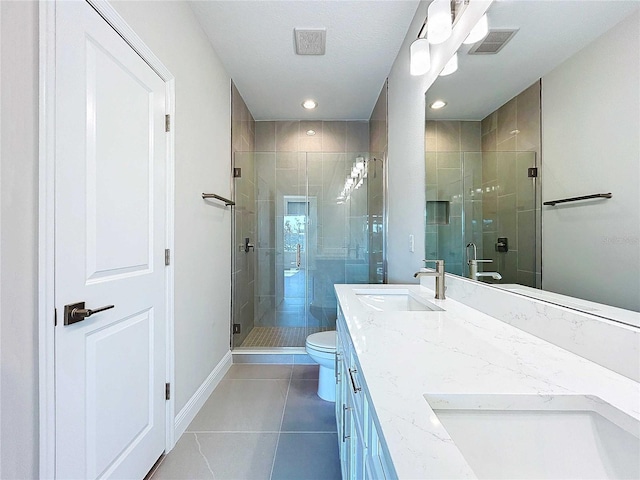 bathroom featuring tile patterned floors, vanity, toilet, and a shower with shower door