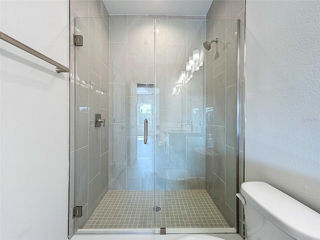 bathroom featuring toilet and an enclosed shower