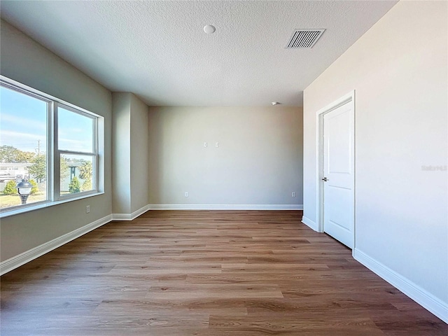 spare room featuring a textured ceiling and light wood-type flooring