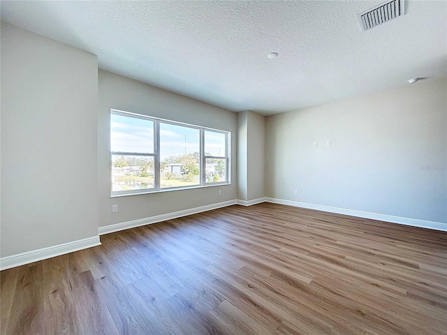 empty room featuring a textured ceiling and hardwood / wood-style flooring