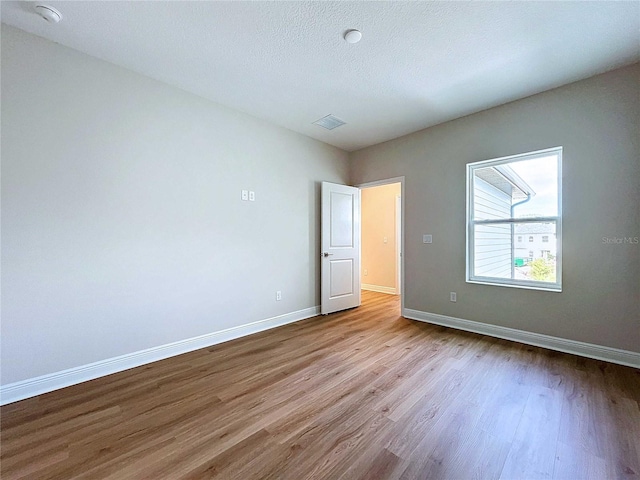 unfurnished bedroom featuring light hardwood / wood-style flooring and a textured ceiling