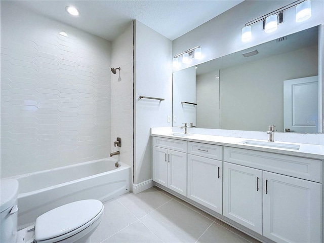 full bathroom featuring tile patterned floors, vanity, tiled shower / bath, and toilet