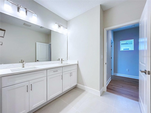 bathroom with vanity, a textured ceiling, and tile patterned flooring