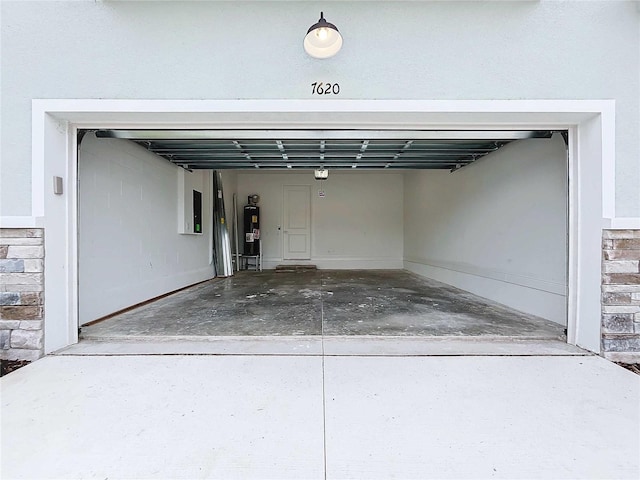 garage featuring electric panel and water heater