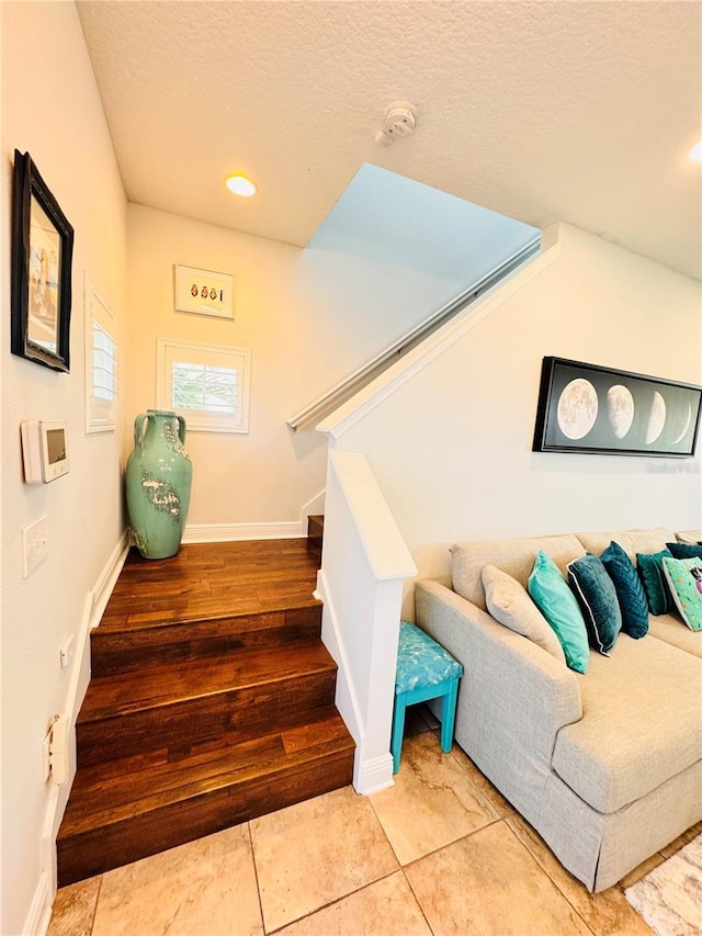 stairs featuring tile patterned floors and a textured ceiling