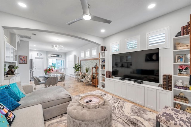 living room with ceiling fan with notable chandelier